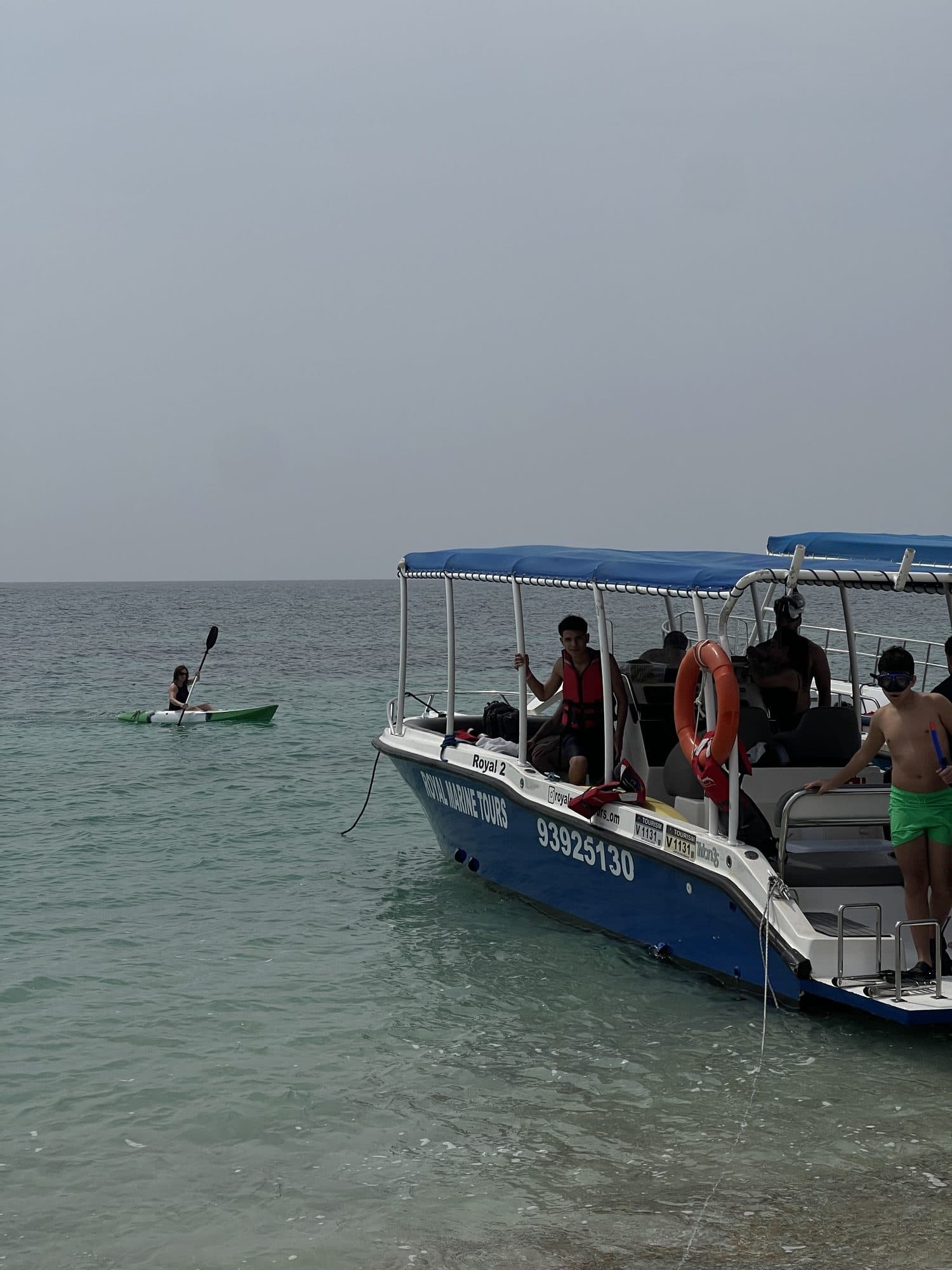 A Royal Marine Tours boat anchored in calm water at the Daymaniyat Islands